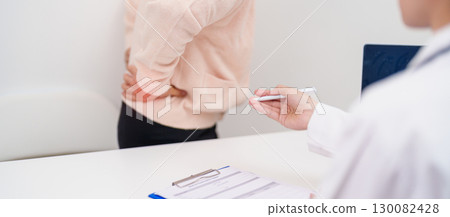 Elderly woman having back body ache and consulting doctor in hospital. Senior female with muscle pain due to Piriformis Syndrome, Low Back Pain and Spinal Compression. Office syndrome and medical 130082428