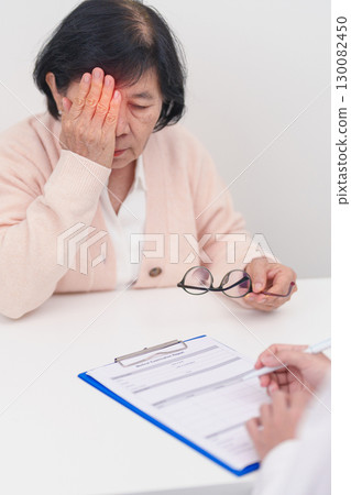 Elderly woman Patient having Eye ache and consulting Doctor to Eye disease. Senior Medical Diagnosis. Cataract, Glaucoma, Age Related Macular Degeneration, Diabetic Retinopathy, Vitreous and health 130082450