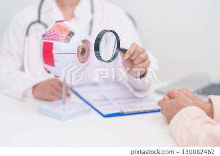Elderly Patient consulting Doctor to Eye disease, Senior Medical Diagnosis. Anatomy Eye model for Cataract, Glaucoma, Age Related Macular Degeneration, Diabetic Retinopathy, Vitreous, health concept 130082462