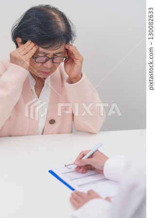 Senior Woman having headache and consulting doctor to disease. Elderly health patient, Medical Diagnosis, Migraine, Brain Tumor, Brain Stroke, Dementia, neurological disorder, alzheimer, Parkinson Senior Woman having headache and consulting doctor to disease. Elderly health patient, Medical Diagnosis, Migraine, Brain Tumor, Brain Stroke, Dementia, neurological disorder, alzheimer, Parkinson 130082633