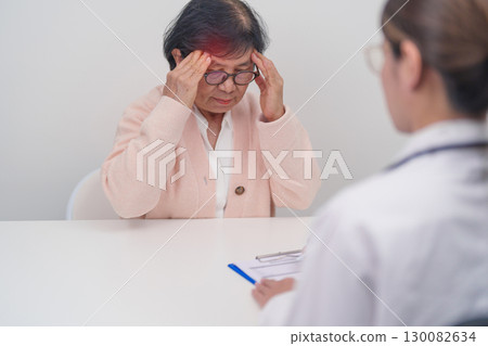 Senior Woman having headache and consulting doctor to disease. Elderly health patient, Medical Diagnosis, Migraine, Brain Tumor, Brain Stroke, Dementia, neurological disorder, alzheimer, Parkinson Senior Woman having headache and consulting doctor to disease. Elderly health patient, Medical Diagnosis, Migraine, Brain Tumor, Brain Stroke, Dementia, neurological disorder, alzheimer, Parkinson 130082634