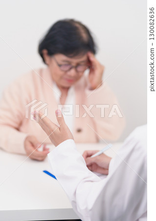 Senior Woman having headache and consulting doctor to disease. Elderly health patient, Medical Diagnosis, Migraine, Brain Tumor, Brain Stroke, Dementia, neurological disorder, alzheimer, Parkinson 130082636