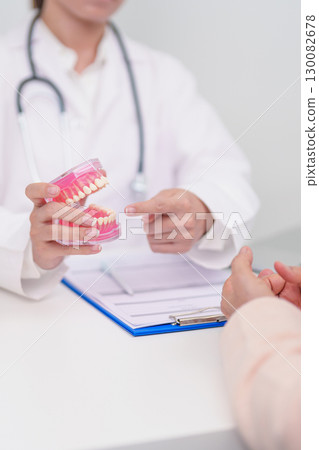 Elderly Patient consulting Dentist to Tooth disease, Senior Health Medical Diagnosis. Anatomy teeth model for Oral Teeth decay, Scrape off tartar. March Oral health, Dentist Day, False Teeth concept Elderly Patient consulting Dentist to Tooth disease, Senior Health Medical Diagnosis. Anatomy teeth model for Oral Teeth decay, Scrape off tartar. March Oral health, Dentist Day, False Teeth concept 130082678