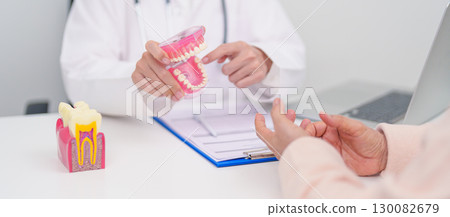 Elderly Patient consulting Dentist to Tooth disease, Senior Health Medical Diagnosis. Anatomy teeth model for Oral Teeth decay, Scrape off tartar. March Oral health, Dentist Day, False Teeth concept Elderly Patient consulting Dentist to Tooth disease, Senior Health Medical Diagnosis. Anatomy teeth model for Oral Teeth decay, Scrape off tartar. March Oral health, Dentist Day, False Teeth concept 130082679