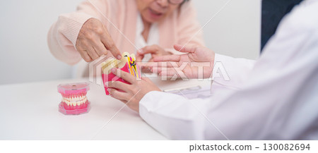 Elderly Patient consulting Dentist to Tooth disease, Senior Health Medical Diagnosis. Anatomy teeth model for Oral Teeth decay, Scrape off tartar. March Oral health, Dentist Day, False Teeth concept Elderly Patient consulting Dentist to Tooth disease, Senior Health Medical Diagnosis. Anatomy teeth model for Oral Teeth decay, Scrape off tartar. March Oral health, Dentist Day, False Teeth concept 130082694