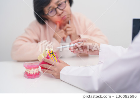 Elderly Patient consulting Dentist to Tooth disease, Senior Health Medical Diagnosis. Anatomy teeth model for Oral Teeth decay, Scrape off tartar. March Oral health, Dentist Day, False Teeth concept 130082696