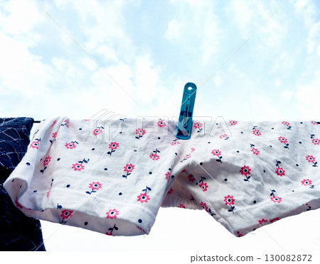 White Fabric with Pink Floral Print Drying on Clothesline 130082872