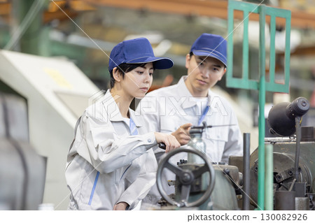 A group of workers inspecting products in a factory A group of workers inspecting products in a factory 130082926