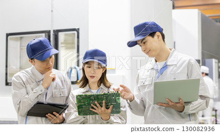 工廠裡的男女工人使用小工具檢查產品 130082936