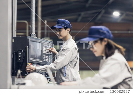 Male and female workers working in a factory 130082937