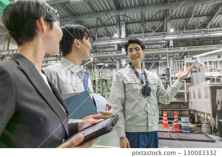 A female business person and a male worker inspecting a factory 130083332