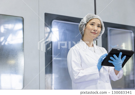 A worker working with a tablet in a factory 130083341