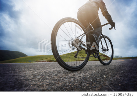 Woman riding bike on mountain top trail 130084383