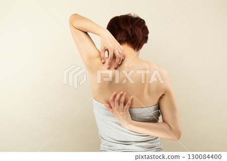 年輕的亞洲女子正在撓背。 130084400
