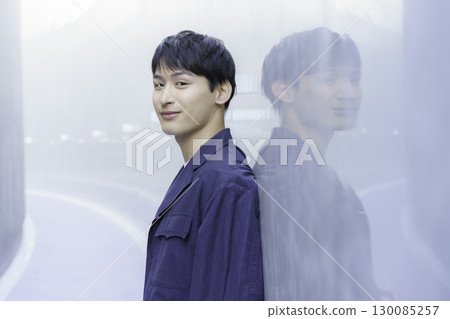 Portrait of a young man in a navy blue jacket 130085257