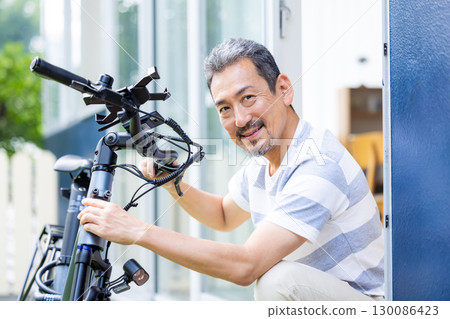 中年男子在維修自行車 中年男子在維修自行車 130086423