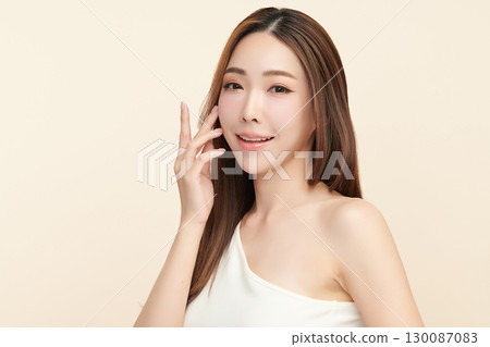 A beautiful young Asian woman with clean, fresh skin against a beige background. Skincare, facial treatment, cosmetology, beauty, and spa. An elegant portrait of an Asian woman. A beautiful young Asian woman with clean, fresh skin against a beige background. Skincare, facial treatment, cosmetology, beauty, and spa. An elegant portrait of an Asian woman. 130087083