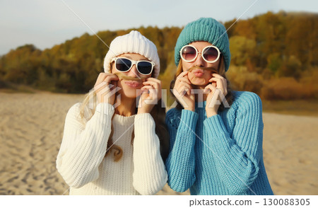 Happy cheerful women friends having fun, funny girlfriends together outdoors in autumn park Happy cheerful women friends having fun, funny girlfriends together outdoors in autumn park 130088305