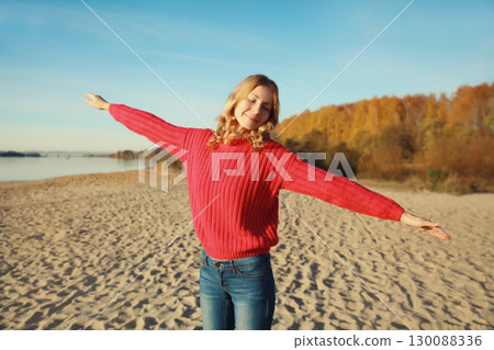 Happy relaxed woman on beach, enjoying warm weather, standing on sea coast Happy relaxed woman on beach, enjoying warm weather, standing on sea coast 130088336
