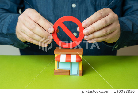 The men hold a NO sign above the store. Business closure, legal restrictions, retail ban, failed investment, economic pressure 130088836