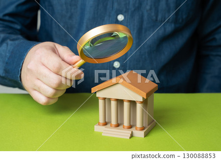 A man investigates a bank. Audit, financial review, compliance, fraud detection, transparency, regulation A man investigates a bank. Audit, financial review, compliance, fraud detection, transparency, regulation 130088853