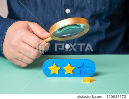 The man is studying the reasons for the loss of the third star in the rating. Bad reviews and quality or service issues. Fix the issues and restore client trust The man is studying the reasons for the loss of the third star in the rating. Bad reviews and quality or service issues. Fix the issues and restore client trust 130088870