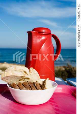 Bread slices and thermos on beach 130089370
