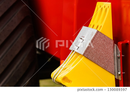 Yellow brake stop blocks wedges on red tractor Yellow brake stop blocks wedges on red tractor 130089397
