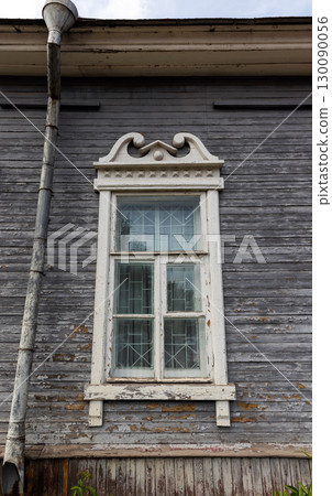 Vintage wooden house exterior showcasing a single white-framed window 130090056