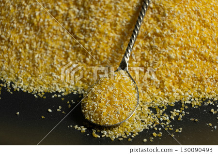 Raw Yellow Corn Grits in a Spoon Raw Yellow Corn Grits in a Spoon 130090493