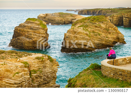 Woman visiting Cathedral Beach in Spain. Woman visiting Cathedral Beach in Spain. 130090817