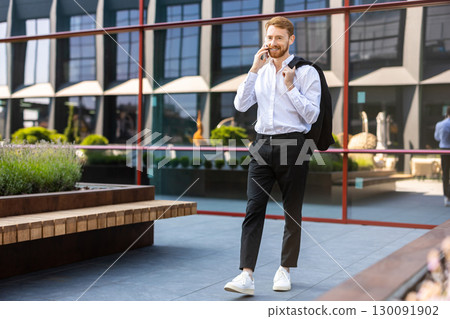 Ginger-haired man in smart outfit speaking on mobile phone 130091902