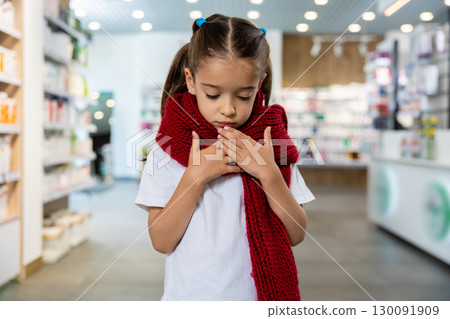 Little cute girl with a red scarf around her neck suffering from a sore throat Little cute girl with a red scarf around her neck suffering from a sore throat 130091909