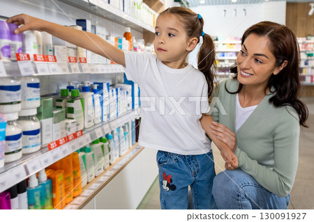 Mom and daughter in the pharmacy choosing medicines Mom and daughter in the pharmacy choosing medicines 130091927
