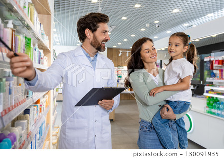 Young mom with a cute kid talking to a pharmacist at the chemists 130091935