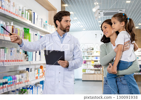 Young mom with a cute kid talking to a pharmacist at the chemists 130091938