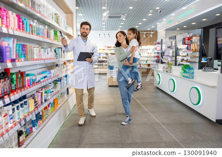 Young mom with a cute kid talking to a pharmacist at the chemists 130091940