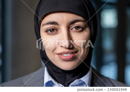 Waist up of a young woman in hijab looking contented 130091946