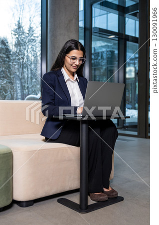 Young woman sitting in the office and working on laptop Young woman sitting in the office and working on laptop 130091966