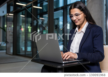 Young woman sitting in the office and working on laptop Young woman sitting in the office and working on laptop 130091968