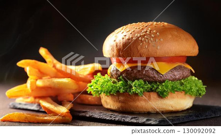 A delicious looking hamburger and fries on a black background 130092092