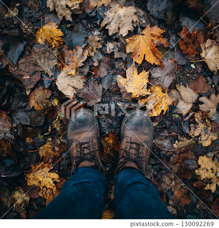 Autumn boots walking on fallen leaves in the forest 130092269