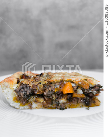 Slice of delicious homemade meat pie with vegetables and herbs on white plate Slice of delicious homemade meat pie with vegetables and herbs on white plate 130092389