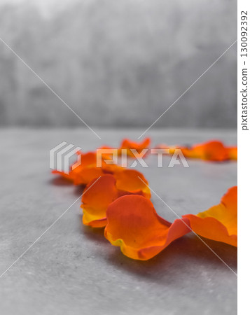 Orange flower petals forming heart shape on marble surface 130092392