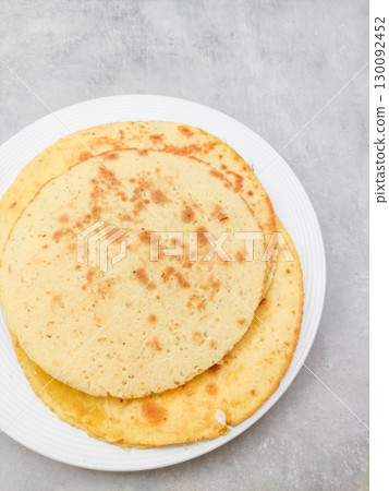 Socca pancakes resting on white plate on gray surface 130092452