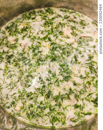 Creamy dill soup simmering in metal pot, comfort food close up Mushroom soup 130092464