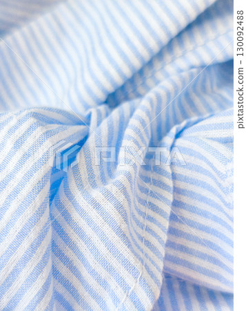 Soft blue and white striped fabric gently folded Soft blue and white striped fabric gently folded 130092488