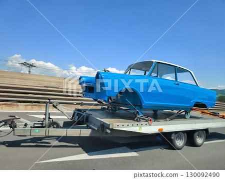Restored classic car body transported on trailer along highway in austria 130092490