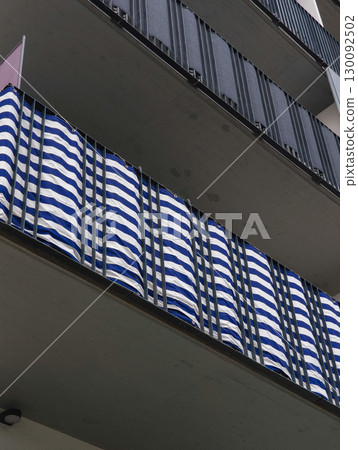 Blue and white striped balcony cover providing privacy and shade in prague 130092502