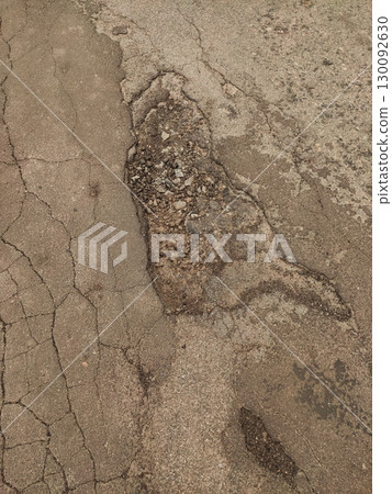 Damaged asphalt road showing cracks and potholes in kokorin, czechia Damaged asphalt road showing cracks and potholes in kokorin, czechia 130092630